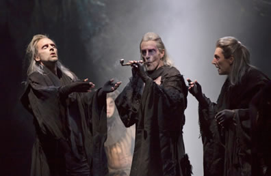 The three weird sisters in long hair and lose black robes and fingerless gloves, the one in the center smoking a pipe, the one on the left enjoying the affects of having just toked on the pipe.